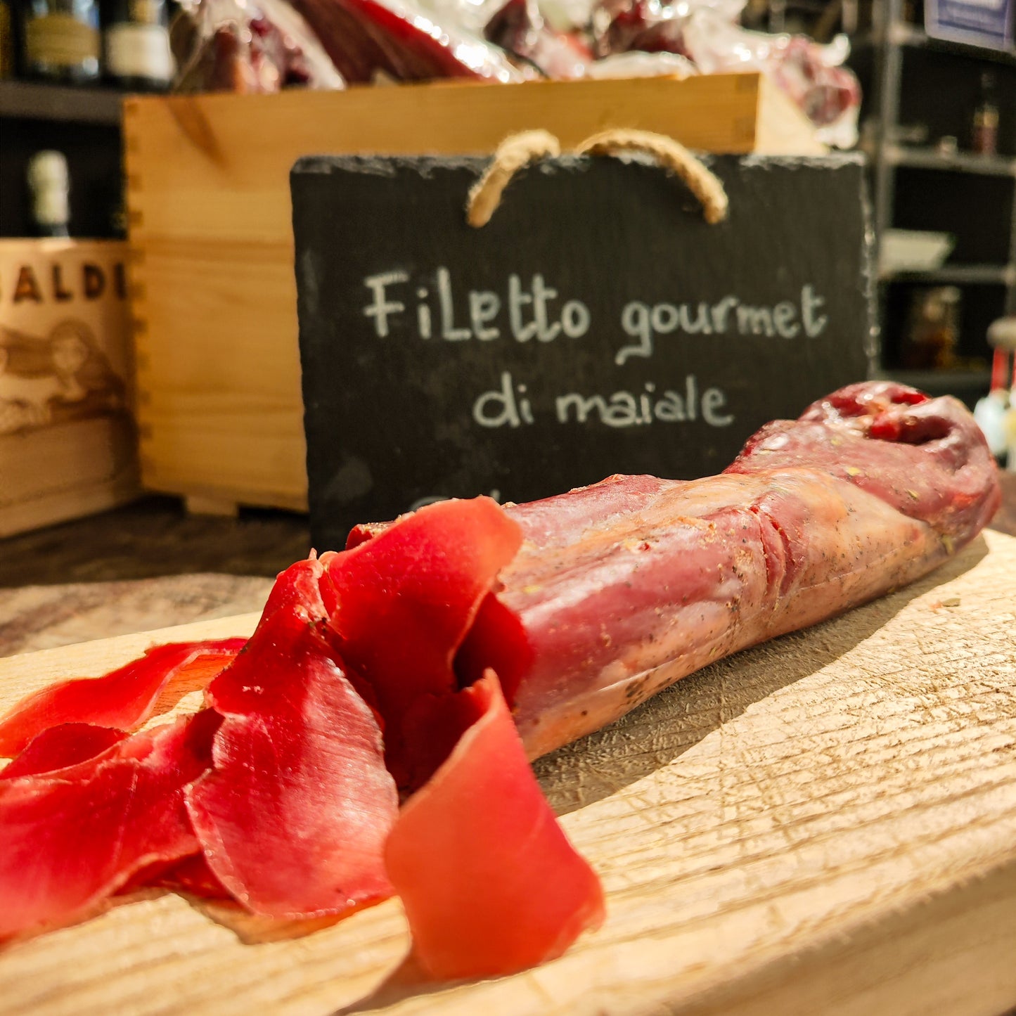 Filetto stagionato di suino/maiale con erbe aromatiche e spezie su tagliere rustico